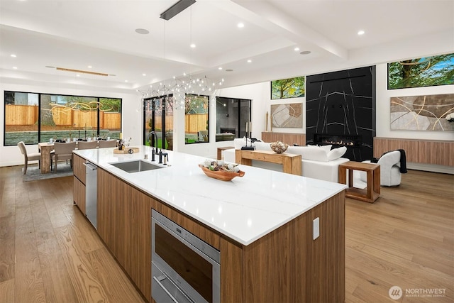 422 98th Ave NE, Bellevue, WA 98004 - kitchen with open floor plan, modern cabinets, a sink, light wood-style flooring, and appliances with stainless steel finishes