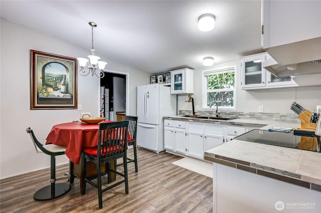 8760 State Highway 303 NE Unit C, Bremerton, WA 98311 - kitchen with an inviting chandelier, a sink, freestanding refrigerator, wood finished floors, and lofted ceiling