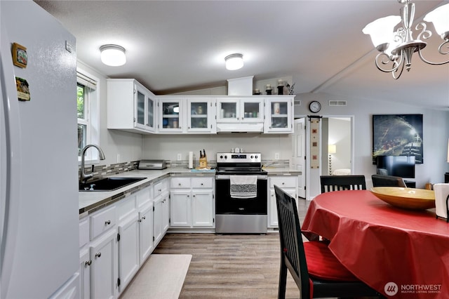 8760 State Highway 303 NE Unit C, Bremerton, WA 98311 - kitchen with freestanding refrigerator, electric range, under cabinet range hood, a sink, and vaulted ceiling