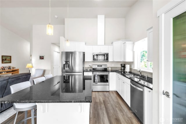 464 Dolphin Ave NE, Ocean Shores, WA 98569 - kitchen with wood finished floors, a kitchen bar, a center island, a sink, and appliances with stainless steel finishes