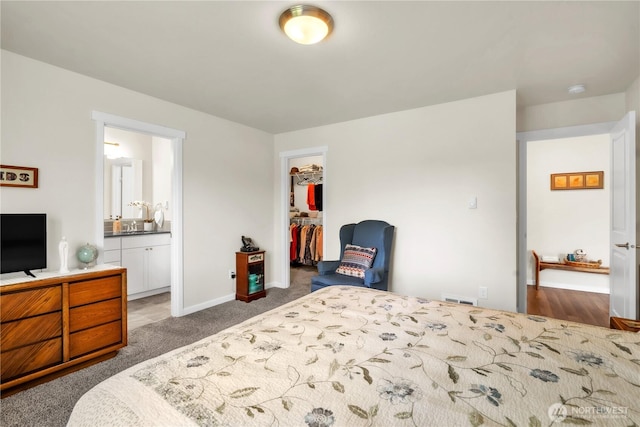464 Dolphin Ave NE, Ocean Shores, WA 98569 - carpeted bedroom with a walk in closet, visible vents, baseboards, a closet, and ensuite bathroom