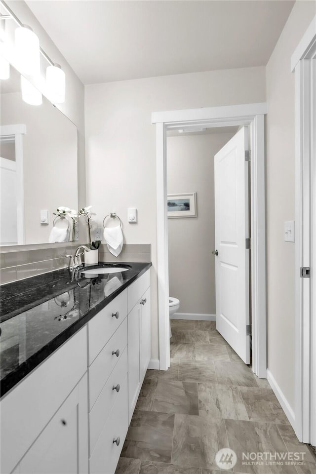 464 Dolphin Ave NE, Ocean Shores, WA 98569 - bathroom featuring vanity, baseboards, and toilet