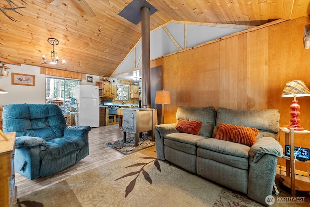 43 Arnica Ln, Twisp, WA 98856 - living area featuring wooden walls, wooden ceiling, wood finished floors, a wood stove, and high vaulted ceiling