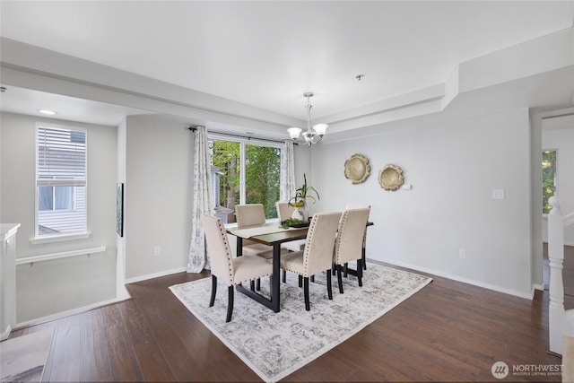 dining area with baseboards, dark wood-type flooring, and a chandelier