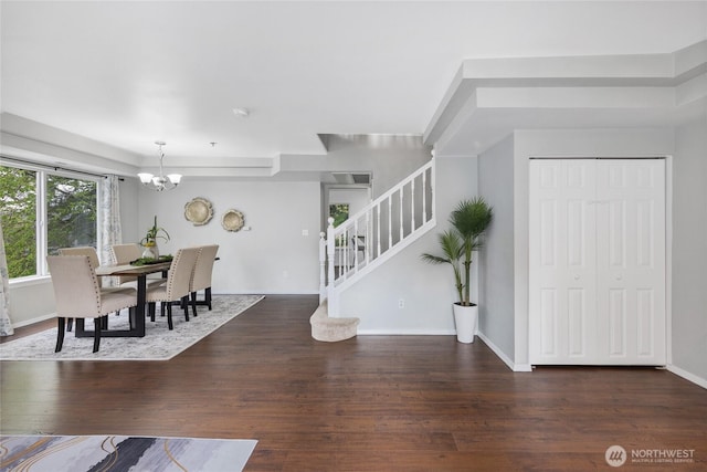 interior space with baseboards, a chandelier, wood finished floors, and stairway