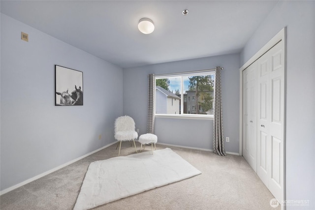 sitting room featuring carpet floors and baseboards