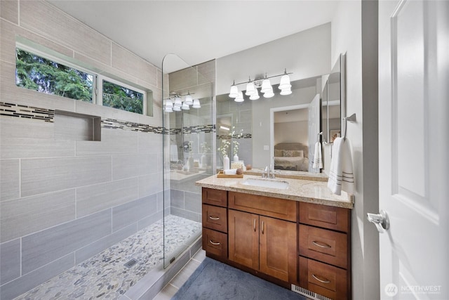 bathroom with vanity, connected bathroom, walk in shower, and visible vents