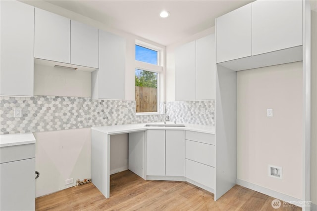 903B NW 56th St, Seattle, WA 98107 - kitchen featuring backsplash, a sink, light countertops, white cabinets, and light wood finished floors