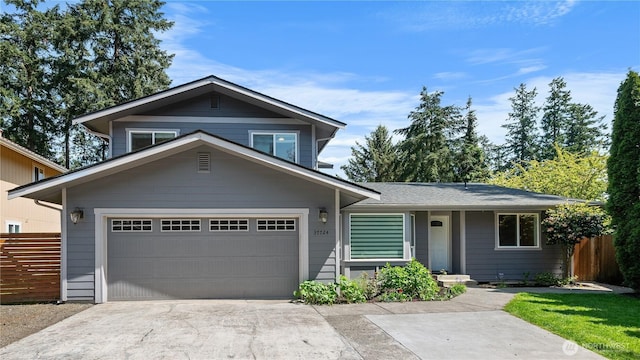 view of front of property with a garage, fence, and concrete driveway