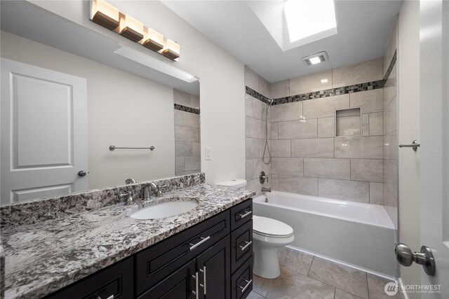 full bath featuring tile patterned flooring, vanity, toilet, shower / bath combination, and a skylight