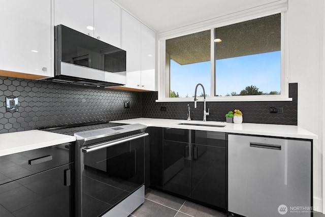 kitchen featuring a sink, light countertops, stainless steel dishwasher, and range with electric cooktop