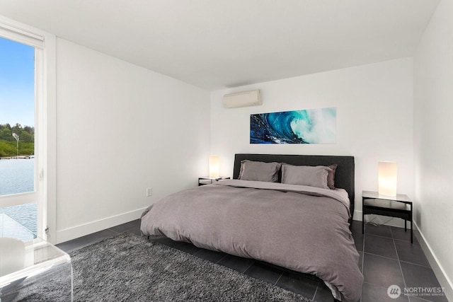 bedroom with an AC wall unit, baseboards, and tile patterned floors
