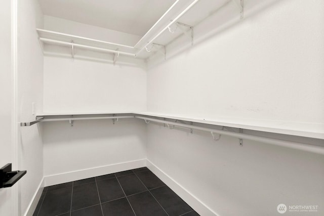 spacious closet with dark tile patterned flooring