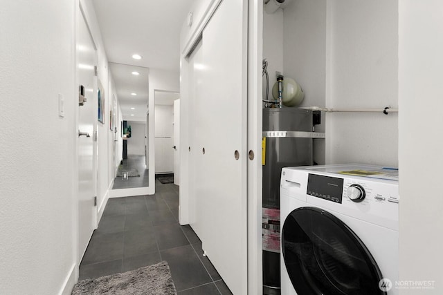 washroom featuring laundry area, washer / clothes dryer, dark tile patterned flooring, water heater, and recessed lighting