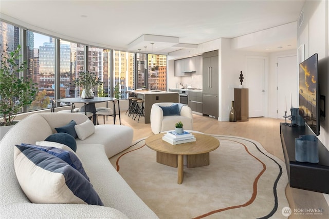 2510 6th Ave Unit 602, Seattle, WA 98121 - living room featuring light wood-type flooring, a view of city, and a wall of windows