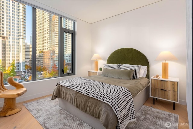 2510 6th Ave Unit 602, Seattle, WA 98121 - bedroom with multiple windows, wood finished floors, and baseboards