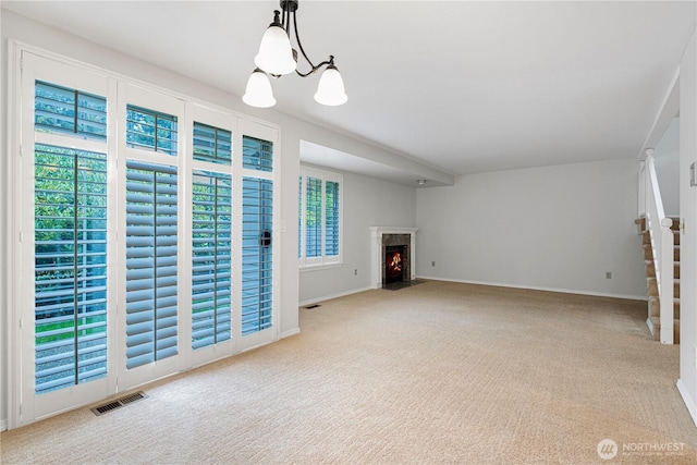 unfurnished living room with carpet flooring, stairs, and baseboards
