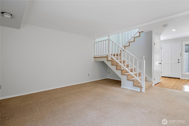 unfurnished living room featuring carpet flooring, stairway, baseboards, and recessed lighting