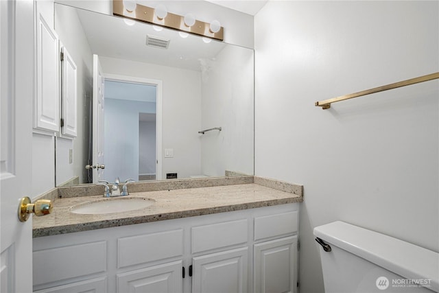half bathroom featuring toilet and vanity