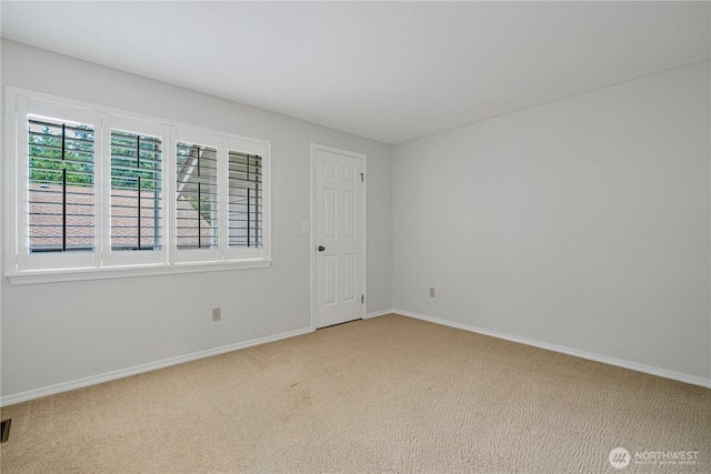 carpeted spare room featuring baseboards