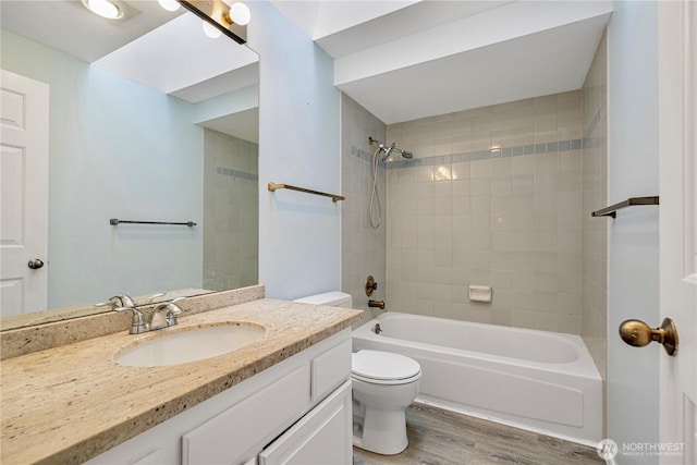 full bath with toilet, wood finished floors, bathing tub / shower combination, and vanity