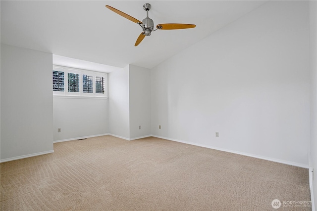 spare room with light carpet, a ceiling fan, baseboards, and lofted ceiling