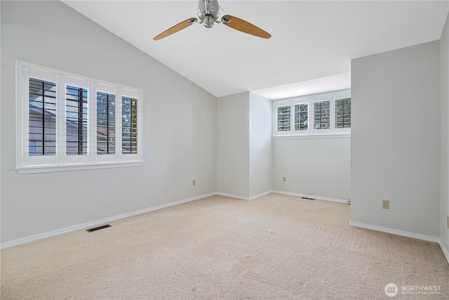 empty room featuring vaulted ceiling, ceiling fan, carpet, and baseboards