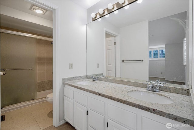 full bath featuring a shower stall, double vanity, toilet, and tile patterned flooring