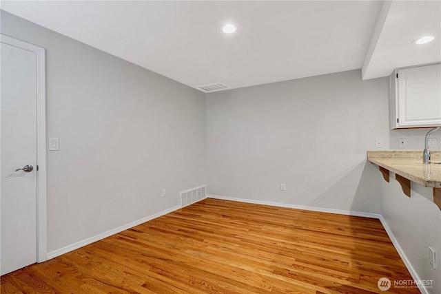 unfurnished dining area featuring light wood-type flooring, baseboards, and recessed lighting