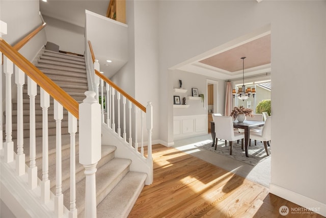 1893 Commodore Ln NW, Bainbridge Island, WA 98110 - stairs featuring wood finished floors, a chandelier, and a raised ceiling