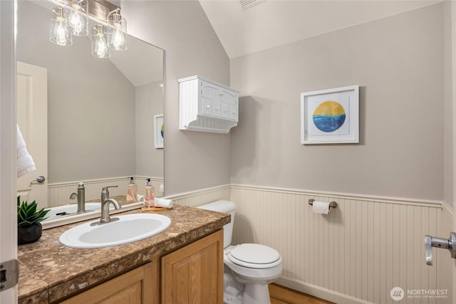 1893 Commodore Ln NW, Bainbridge Island, WA 98110 - bathroom with wainscoting, toilet, lofted ceiling, vanity, and wood finished floors