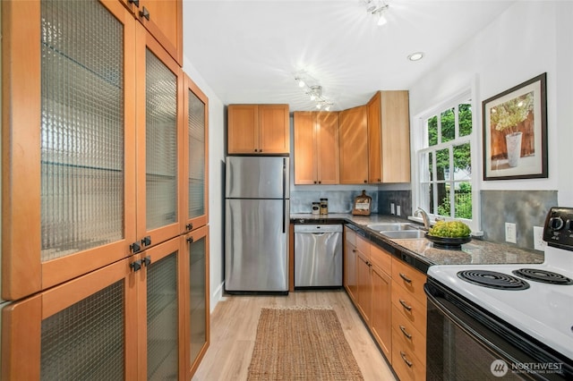 10515 NE 189th St, Bothell, WA 98011 - kitchen with appliances with stainless steel finishes, a sink, light wood-style flooring, backsplash, and glass insert cabinets