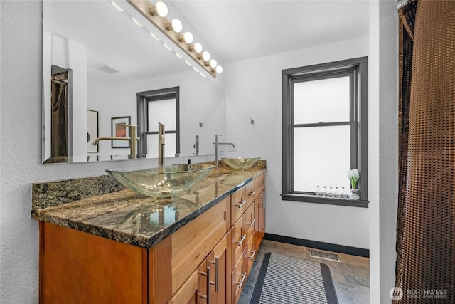 5107 23rd Ave W, Everett, WA 98203 - bathroom featuring double vanity, baseboards, visible vents, and a sink