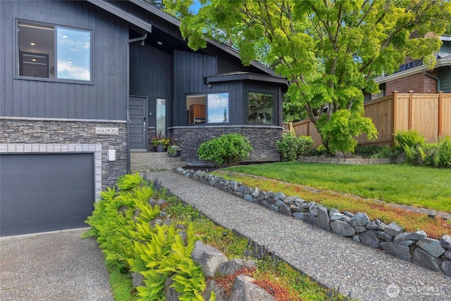 5107 23rd Ave W, Everett, WA 98203 - exterior space with an attached garage, fence, a yard, and stone siding