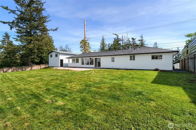 rear view of house featuring a patio area, fence, and a yard