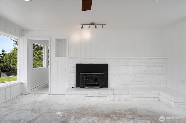interior details with a fireplace with raised hearth and a ceiling fan