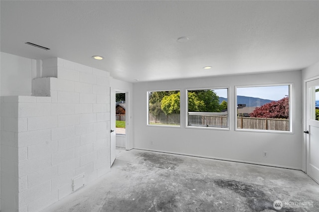 unfurnished room with visible vents, recessed lighting, concrete flooring, and a wealth of natural light