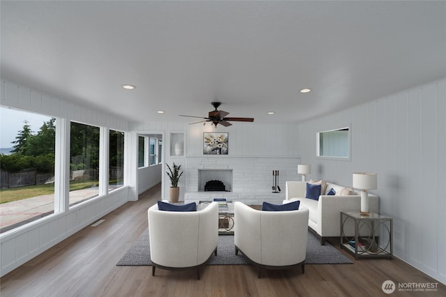 5310 Sunset Ave, Anacortes, WA 98221 - living area with wood finished floors, ceiling fan, a brick fireplace, and recessed lighting