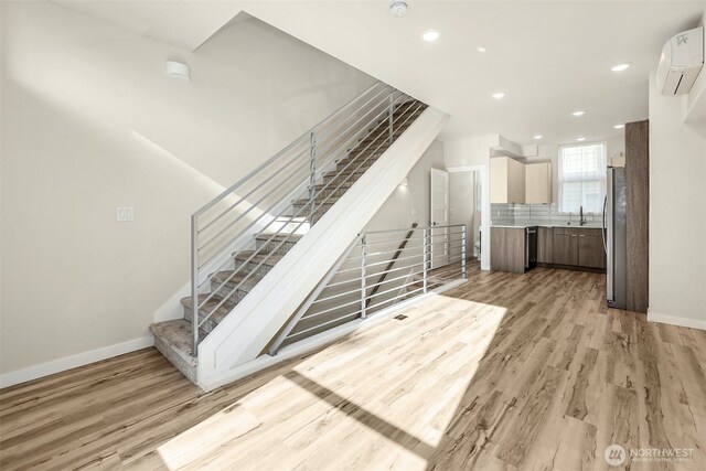 stairs with an AC wall unit, recessed lighting, baseboards, and wood finished floors