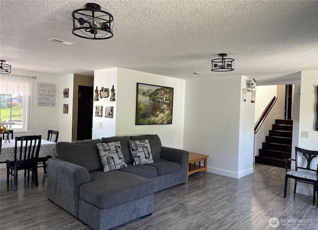 1017 Ballentine St, Raymond, WA 98577 - living area with a textured ceiling, visible vents, wood finished floors, stairway, and baseboards