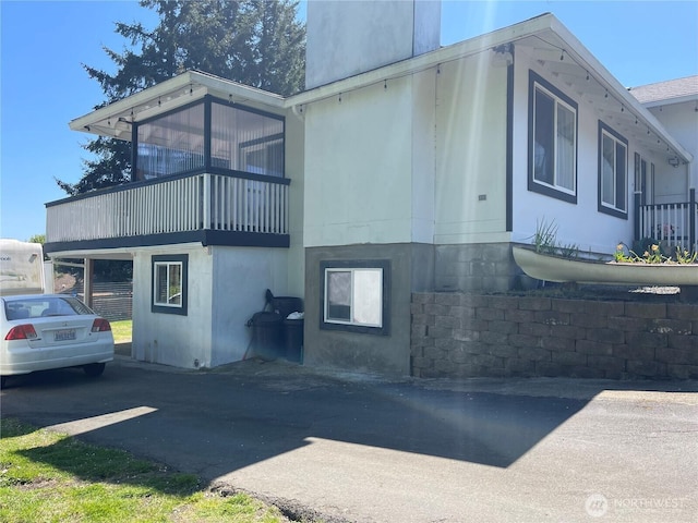 1017 Ballentine St, Raymond, WA 98577 - view of side of home featuring stucco siding and a balcony