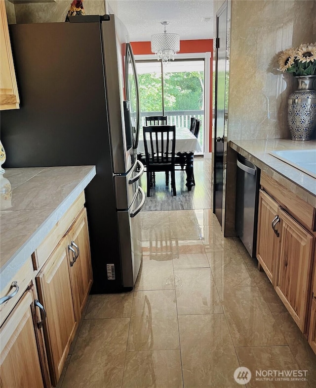 1017 Ballentine St, Raymond, WA 98577 - kitchen featuring light countertops, a sink, appliances with stainless steel finishes, and a notable chandelier