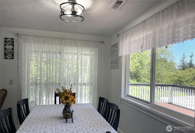 1017 Ballentine St, Raymond, WA 98577 - dining room featuring a notable chandelier, a textured ceiling, and visible vents