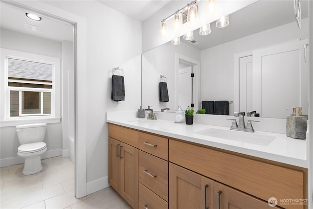 12402 40th Ave NW, Gig Harbor, WA 98332 - bathroom with toilet, double vanity, baseboards, and a sink