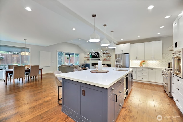 kitchen with stainless steel appliances, white cabinetry, and decorative backsplash