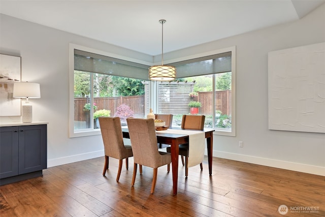 dining room with baseboards and hardwood / wood-style floors
