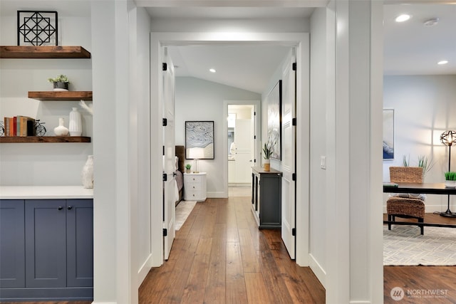 hallway with dark wood-type flooring, baseboards, lofted ceiling, and recessed lighting