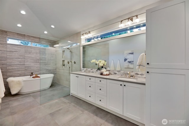 full bathroom with a sink, a walk in shower, tile patterned flooring, a soaking tub, and double vanity