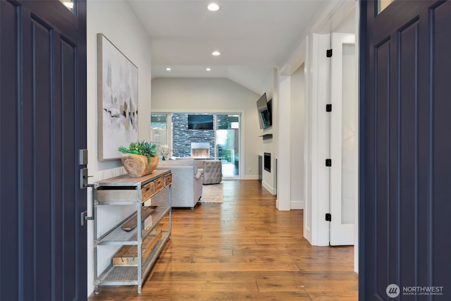 hall with vaulted ceiling, wood-type flooring, baseboards, and recessed lighting