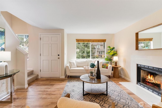 living area with plenty of natural light, stairs, and light wood-type flooring